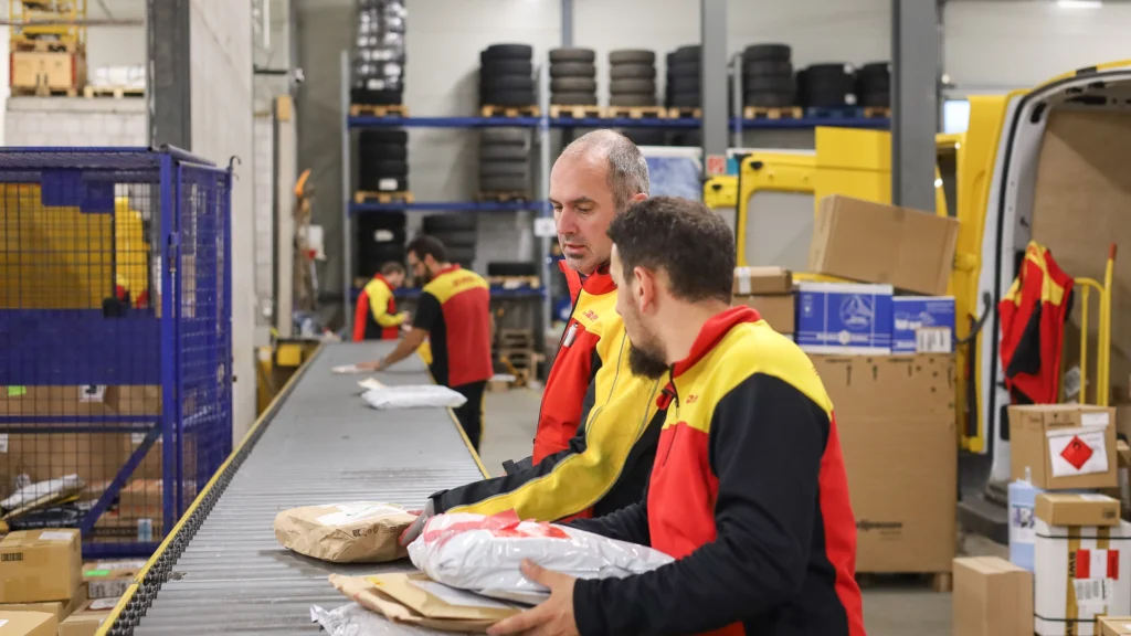 DHL Mitarbeiter sortieren Pakete in Verteilerzentrum Thun