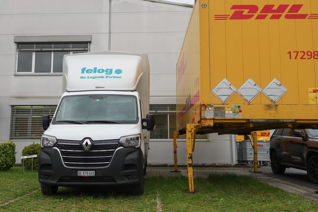 Büro Felog AG Thun mit Transporter und DHL Container